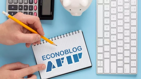 Manos escribiendo en cuaderno con logo de AFIP