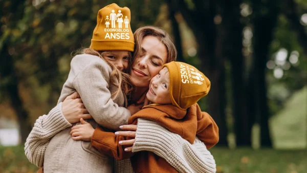 Madre de la AUH con sus hijas con gorro de Anses