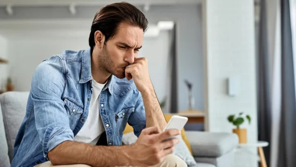 Molesto con el teléfono celular en la mano