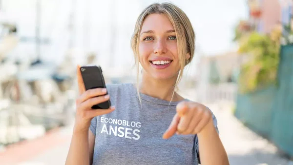 Mujer con celular y remera de Anses