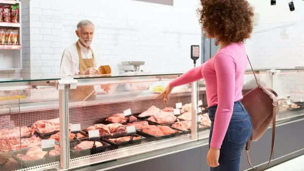 Mujer comprando en la carnicería