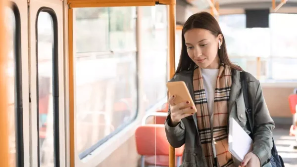 Estudiante con su celular en el colectivo