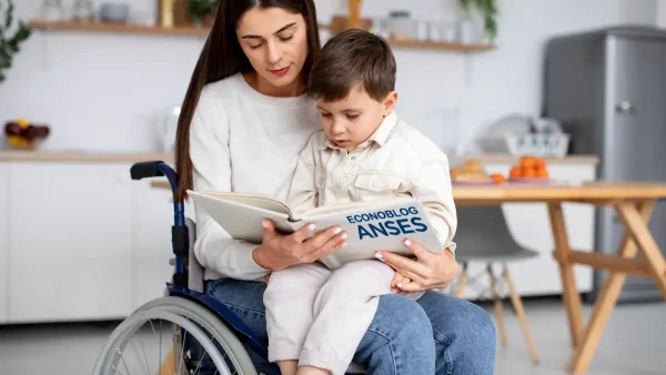 Madre titular de PNC con su hijo y un libro de Anses