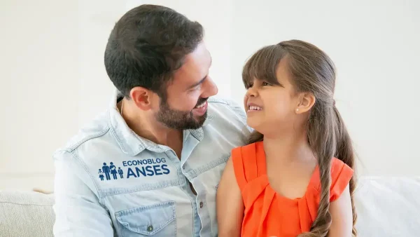 Padre de la AUH con su hija y camisa de la Anses