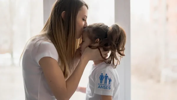 Madre con su hija con remera del SUAF de Anses