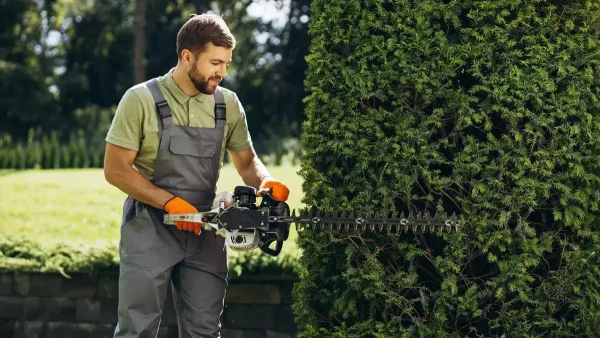 Jardinero con una motosierra en un parque