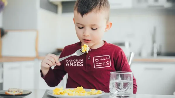 Niño beneficiario de la Tarjeta Alimentar con remera de Anses