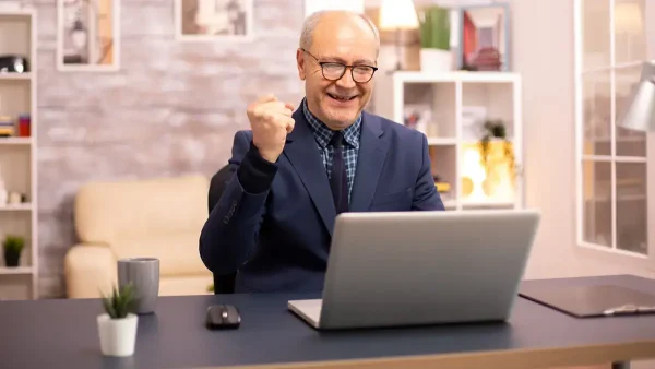 Jubilado contento frente a una computadora