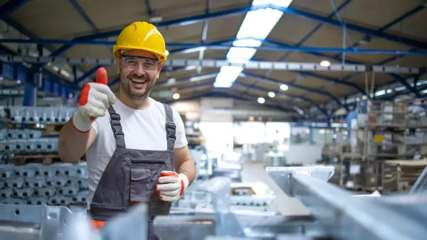 Trabajador feliz con casco en su puesto de trabajo