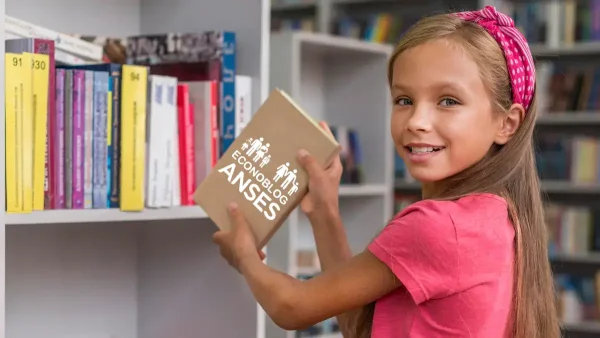 Niña con libro de la AUH y SUAF de Anses