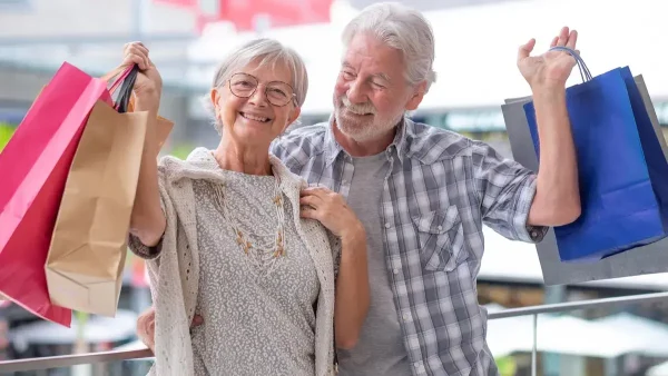 Jubilados de compras con bolsas en las manos