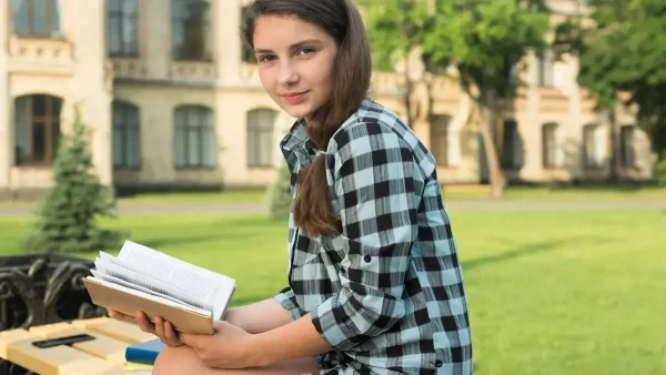 Estudiante leyendo un libro en el parque