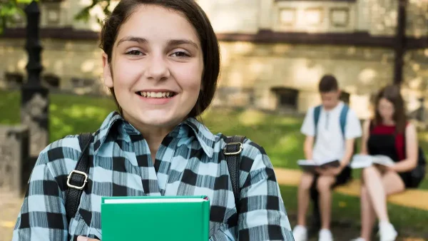 Estudiante contenta con un libro en la mano