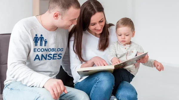 Familia del SUAF con un libro y remera de Anses