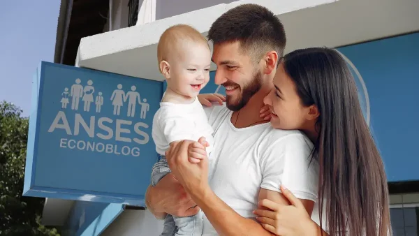 Familia con bebé frente a cartel de Anses para AUH y SUAF