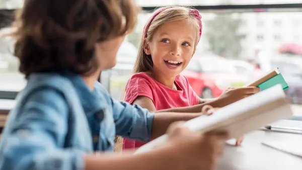 Dos niños leyendo contentos