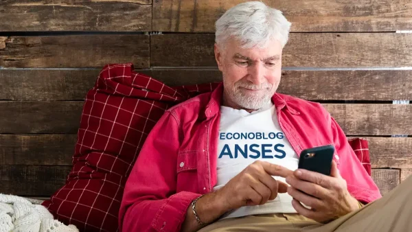 Jubilado de Anses usando su celular