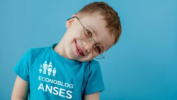 Niño de la AUH con lentes y remera de Anses