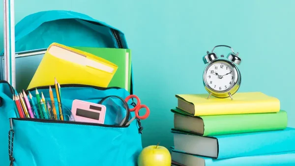 Mochila de un estudiante junto a un reloj