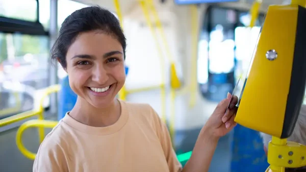 Joven sacando un pasaje en el colectivo