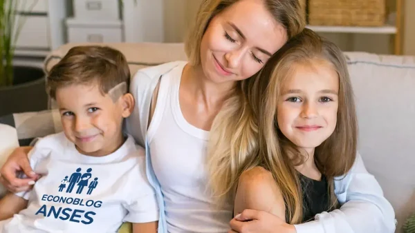 Madre de la AUH con sus hijos usando una remera de Anses