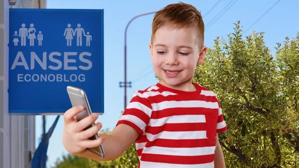 Niño con su celular junto a cartel de Anses para AUH y SUAF