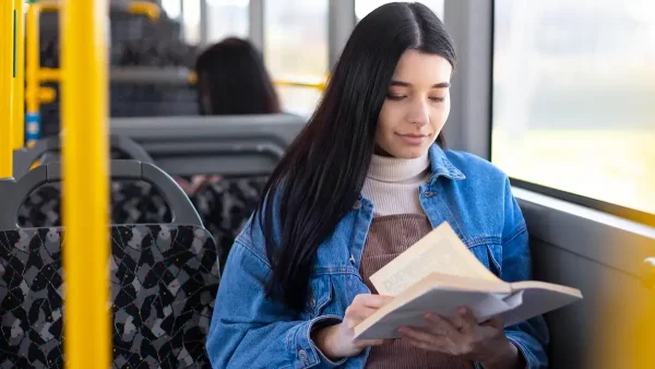 Leyendo un libro en el colectivo