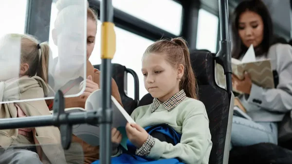 Estudiante con un libro en el colectivo