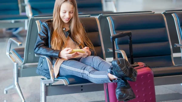 Adolescente con una valija en un aeropuerto