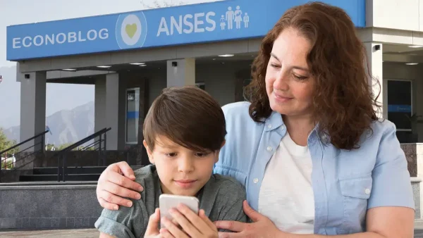 Madre con su hijo frente a cartel de Anses para AUH