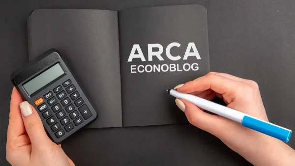 Cuaderno negro de ARCA junto a calculadora