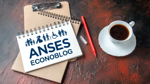 Cuaderno de la Anses junto a taza de café