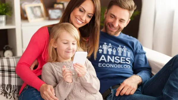 Familia con celular y remera de Anses para AUH y SUAF
