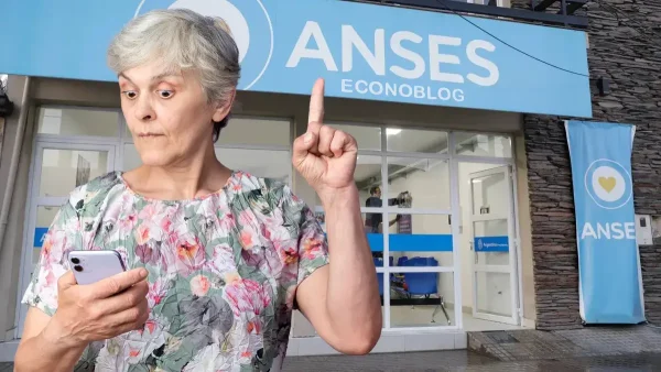 Jubilada con su celular frente a Anses