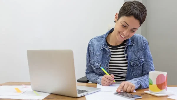 Mujer con una computadora y celular