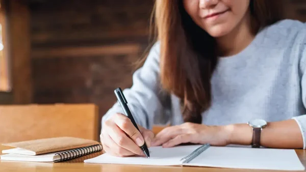 Estudiante escribiendo en un escritorio