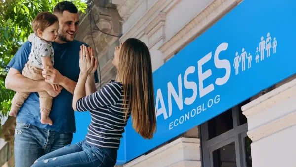 Familia junto a cartel de Anses para SUAF y AUH