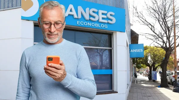 Jubilado con su celular frente a Anses