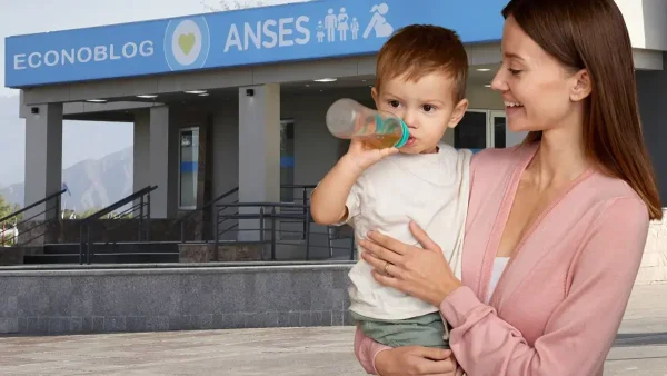 Madre con bebé junto a cartel de Anses para AUH y AUE